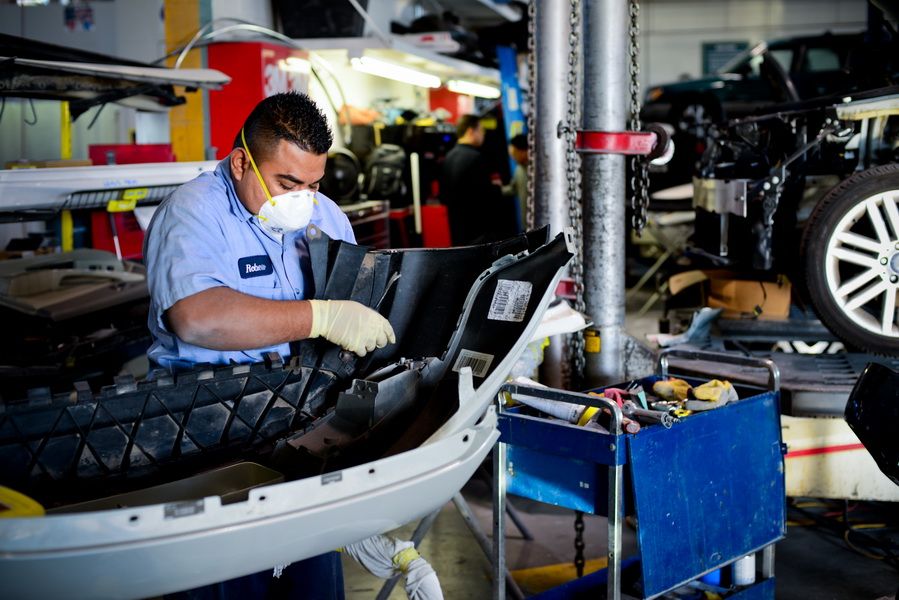Mechanic Working Underneath Car On Lift | D&V Autobody