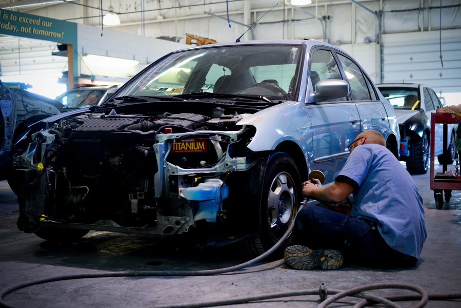 Mechanic Repairing Front End Of Black Car | D&V Autobody
