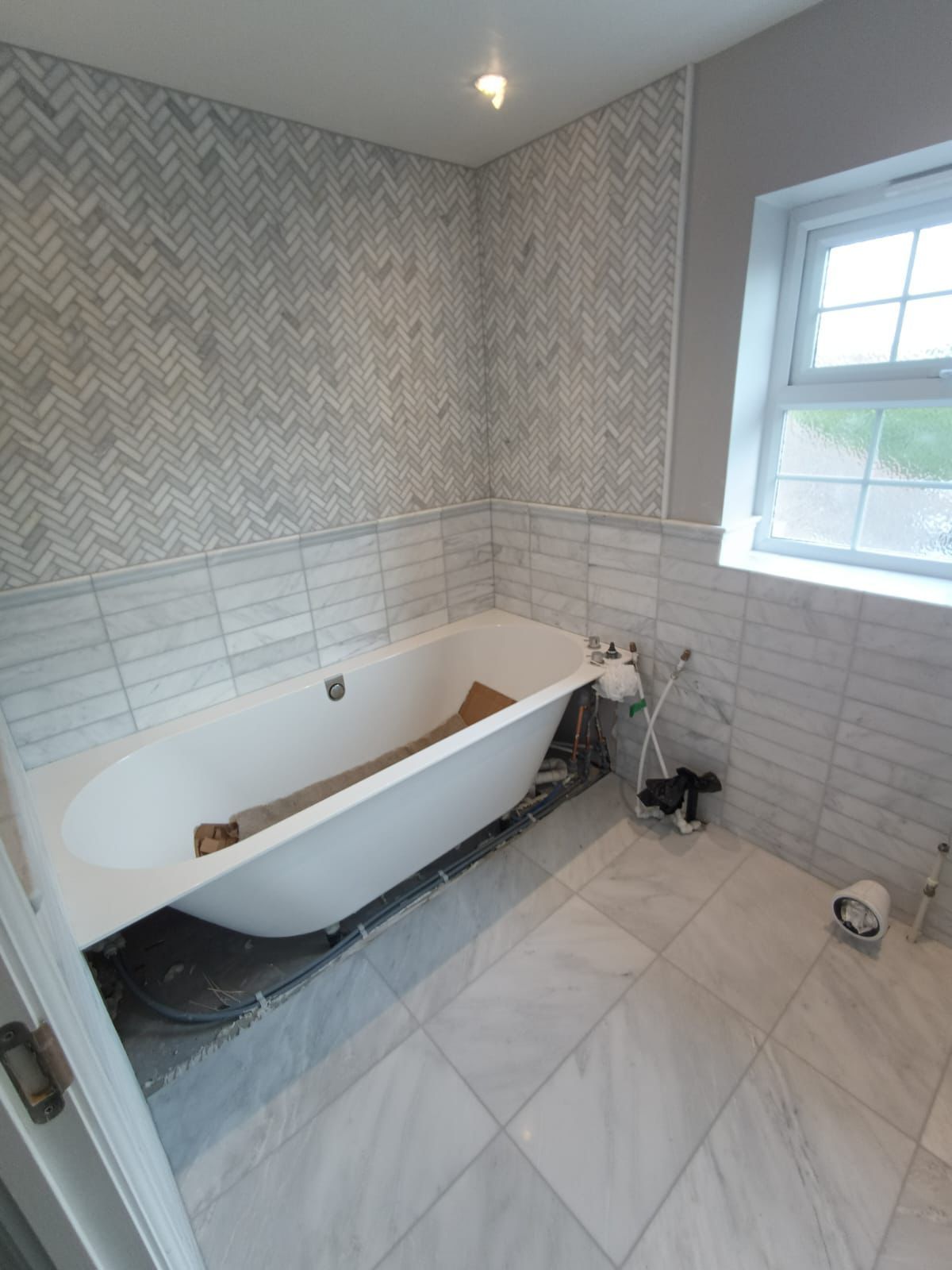 A bathroom with a bathtub and a window.