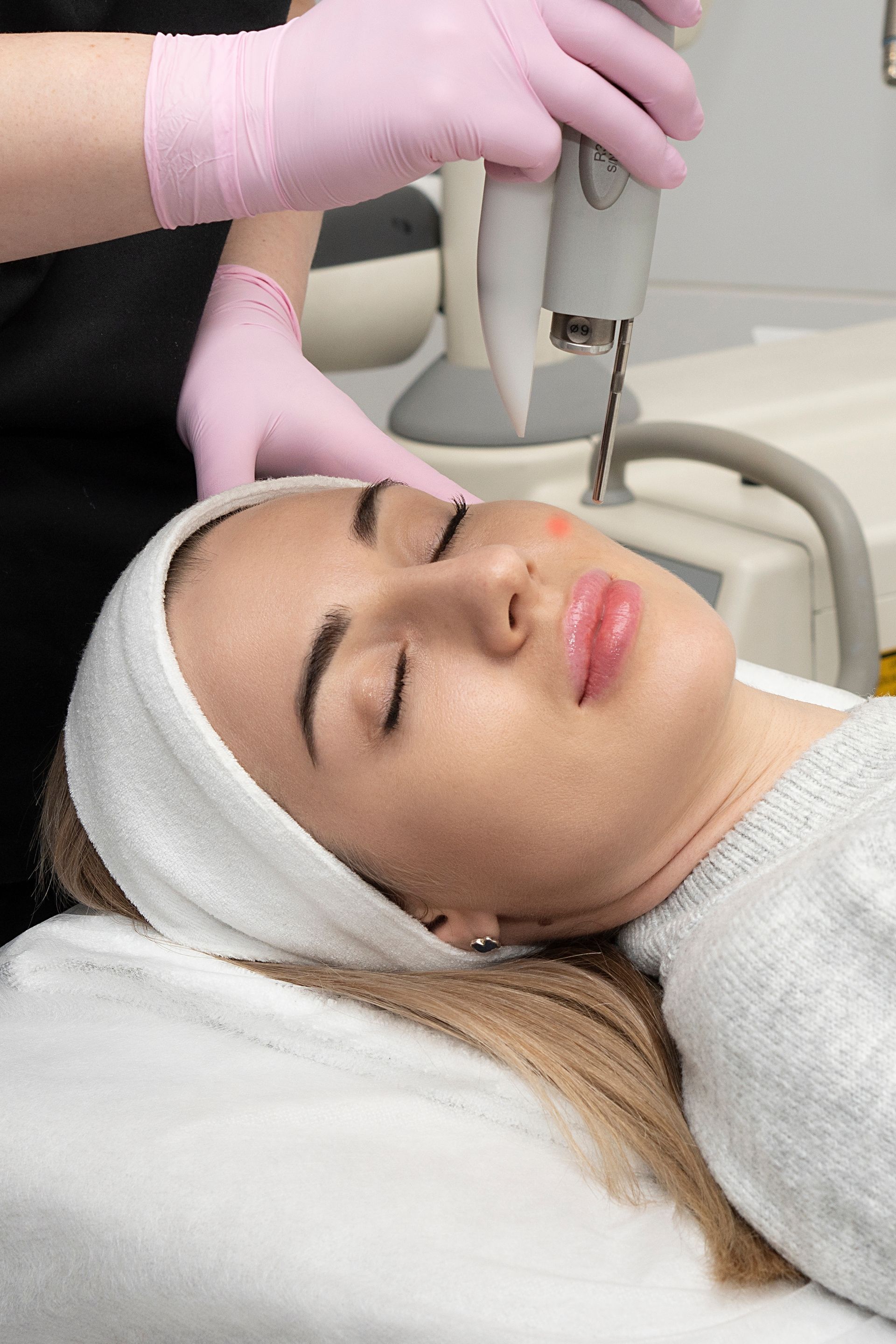 A woman is getting a laser treatment on her face.