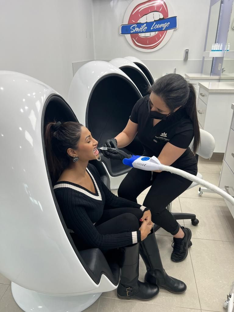 A woman is getting her teeth whitened in a medical clinic