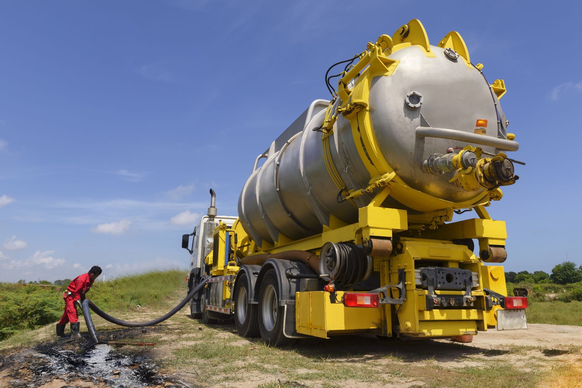 Yellow and Silver Vacuum Truck, Operator in Red Coveralls — Allquip Rentals Pty Ltd in Cooroy, QLD