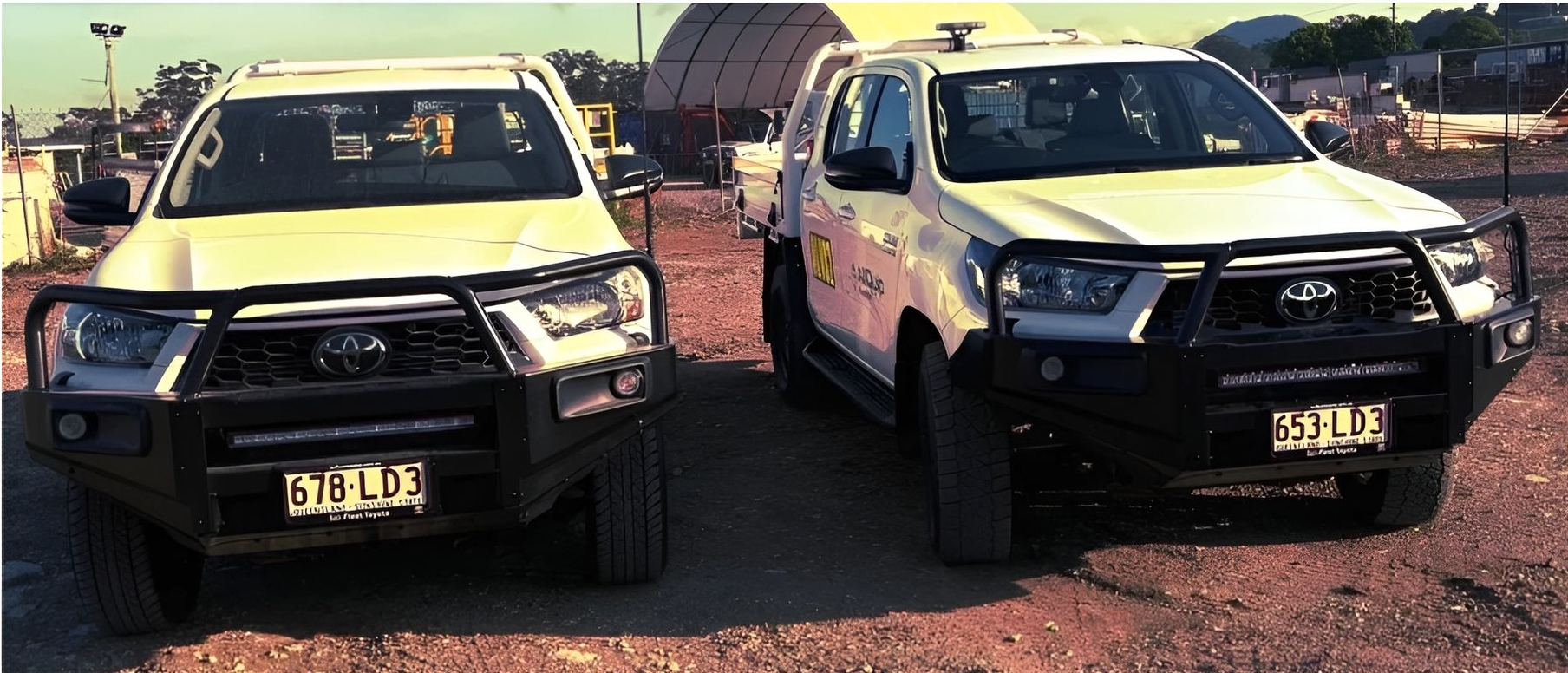 Two White Toyota Trucks With Black Bull Bars Parked on Dirt — Allquip Rentals Pty Ltd in Cooroy, QLD