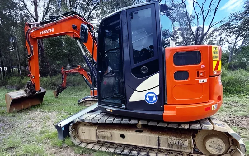 Orange Hitachi Excavator on Tracks in Grassy Area — Allquip Rentals Pty Ltd in Cooroy, QLD