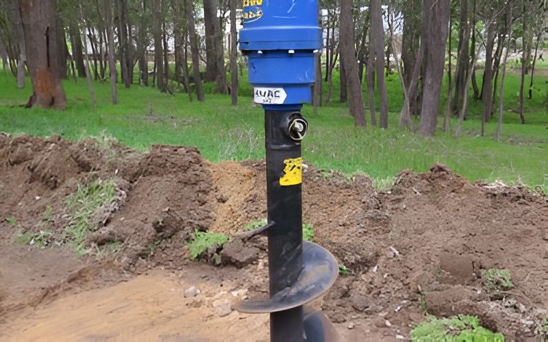 Auger Drill, Blue Motor, Black Drill Bit in Dirt — Allquip Rentals Pty Ltd in Cooroy, QLD