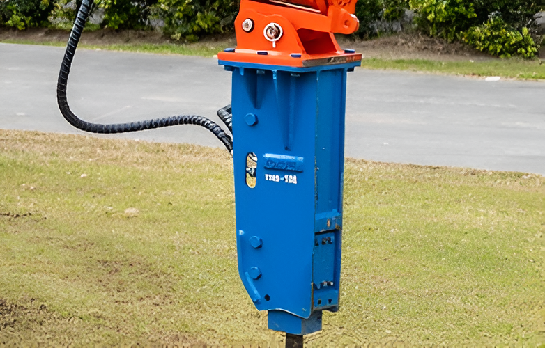 Blue and Orange Hydraulic Breaker on Grass — Allquip Rentals Pty Ltd in Cooroy, QLD
