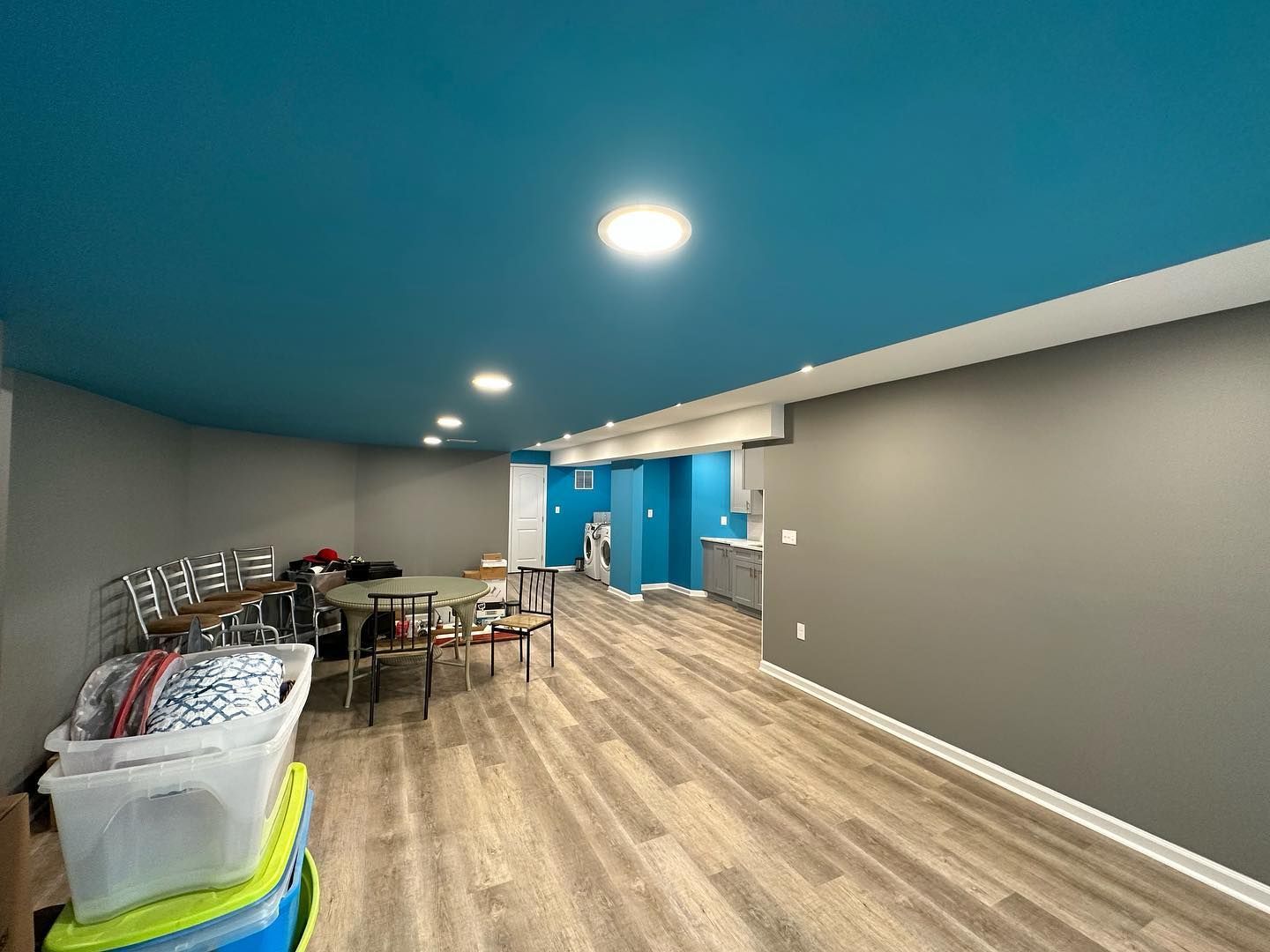 A large room with a blue ceiling and wooden floors.