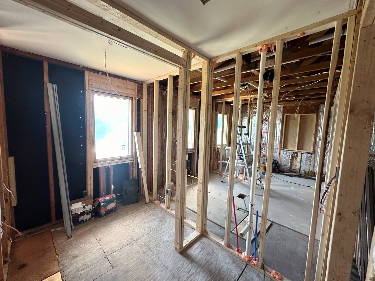 A room with a lot of wooden frames and a ladder in it.