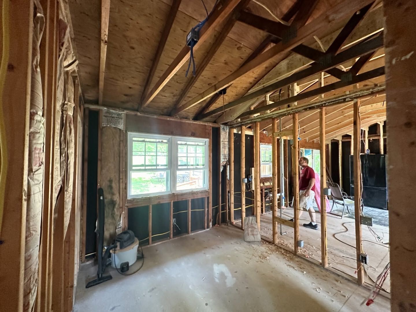 A man is standing in a room that is being built.