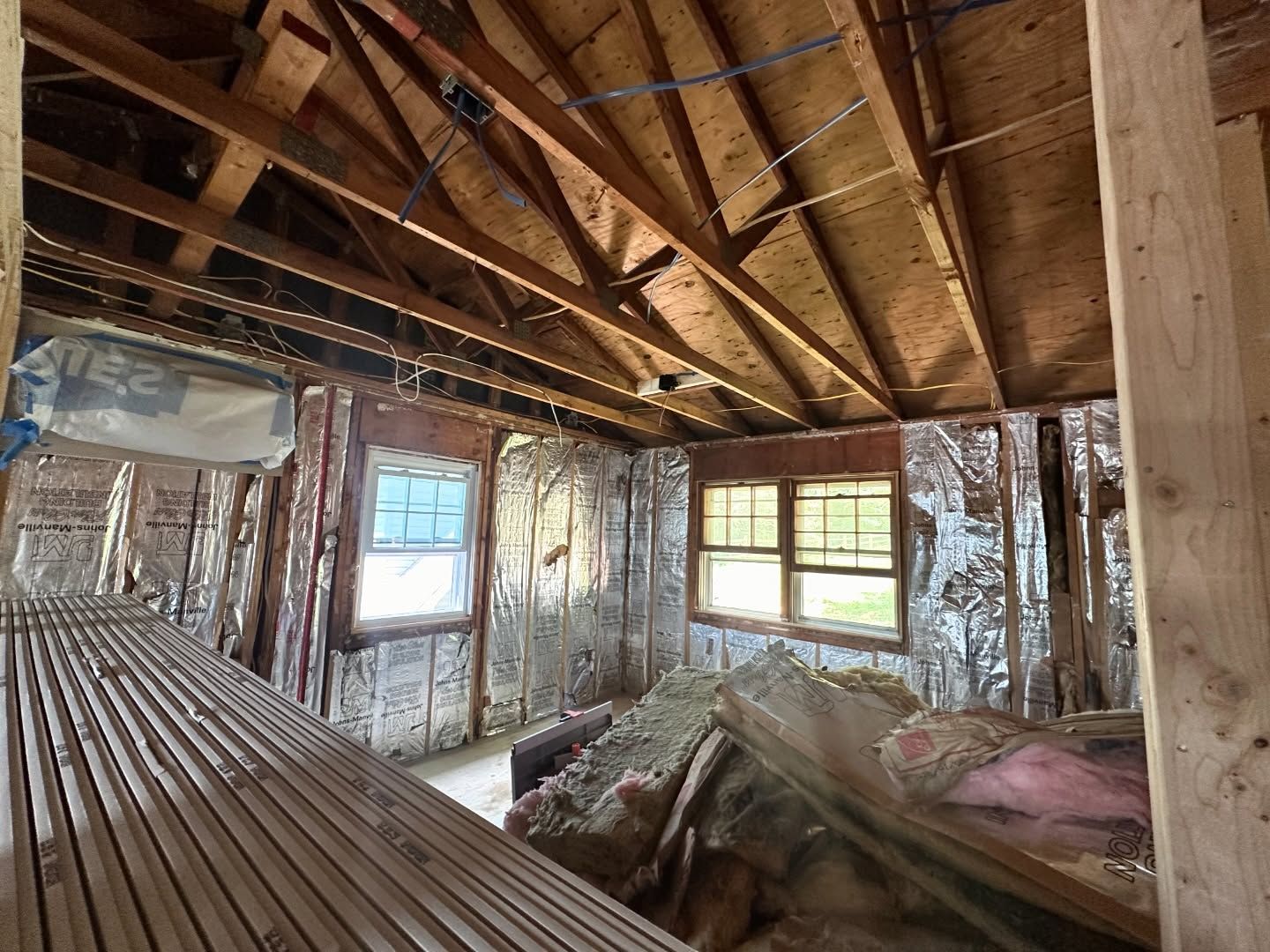 A room with a wooden ceiling and a lot of windows.
