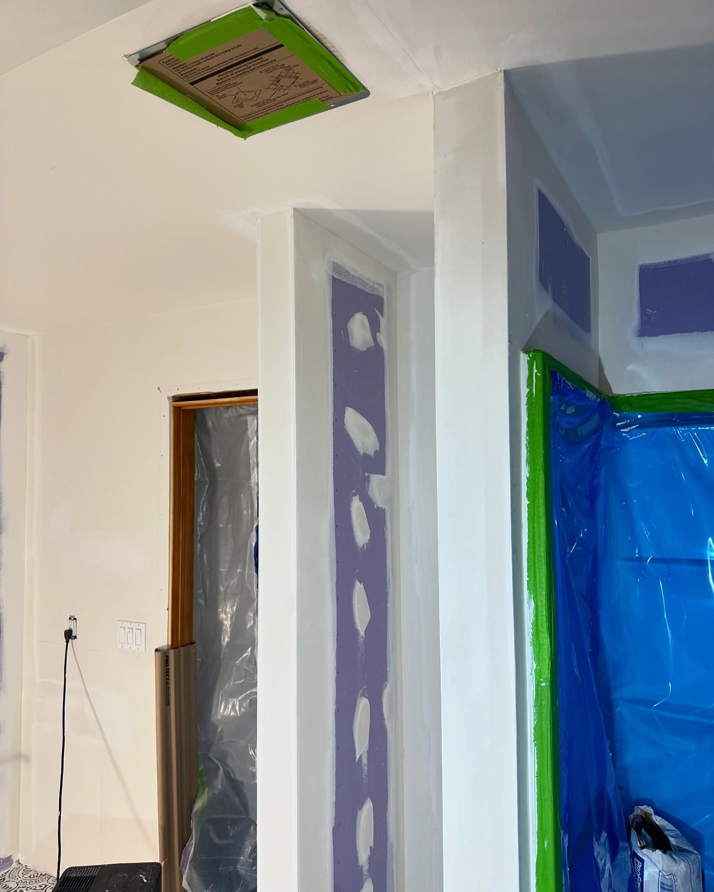 A room that is being painted with purple and white walls