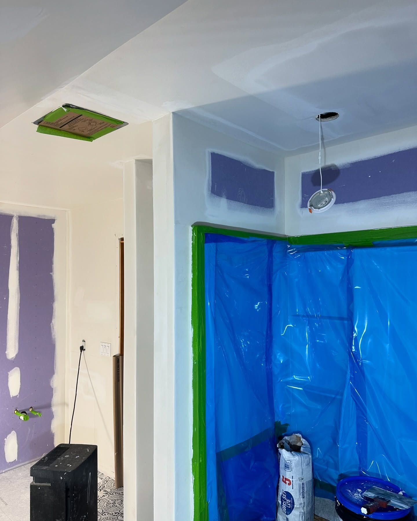 A room under construction with a blue tarp on the floor