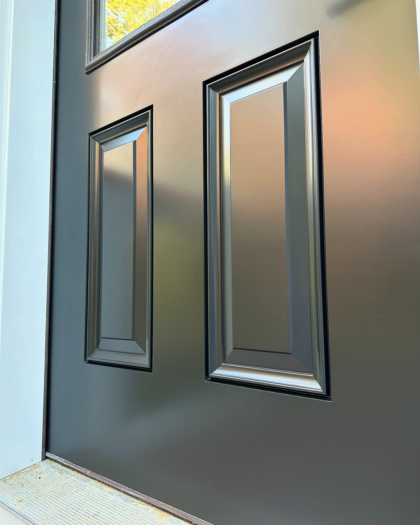 A close up of a black door with two windows