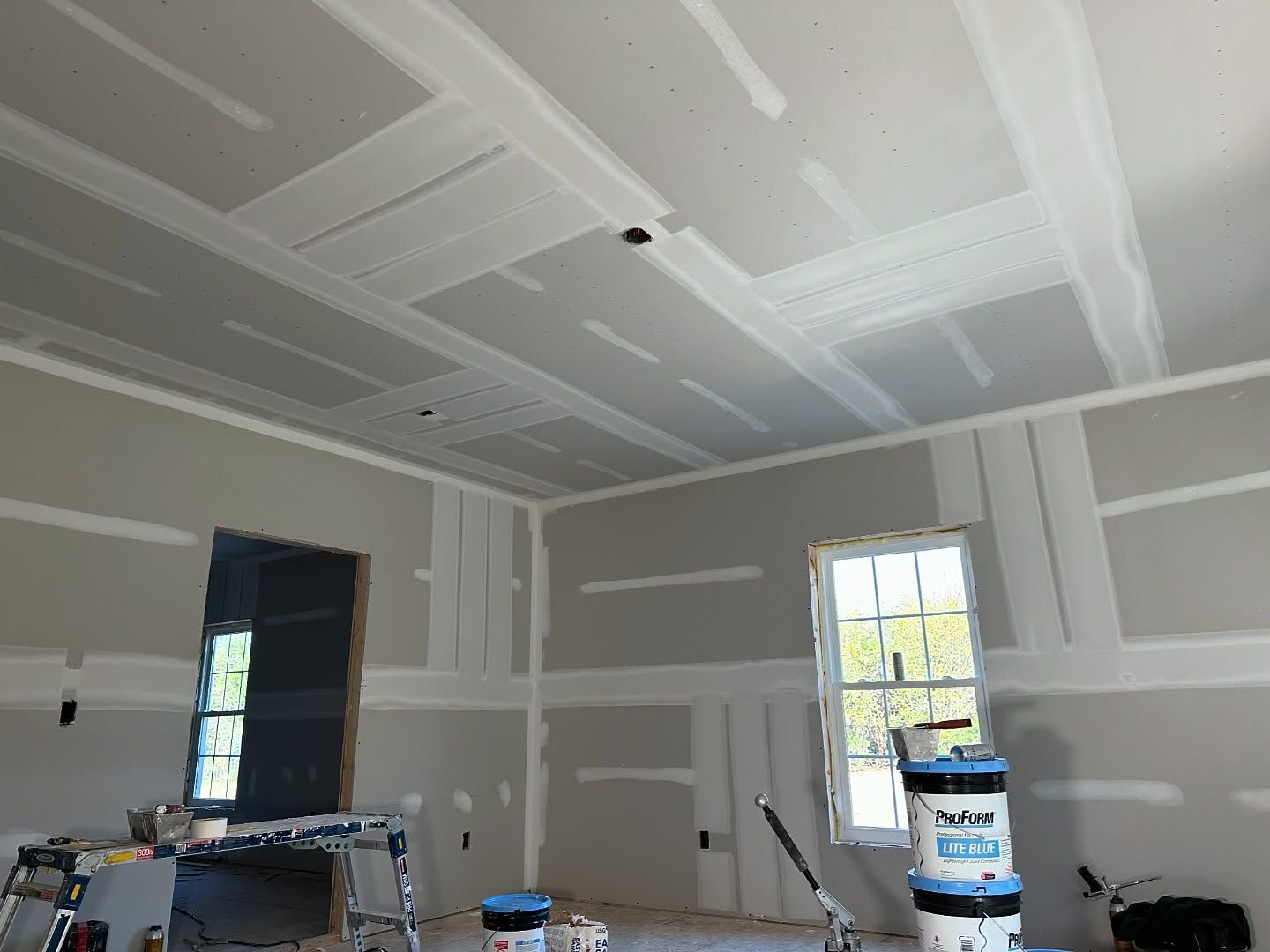 A room that is being painted with buckets of paint
