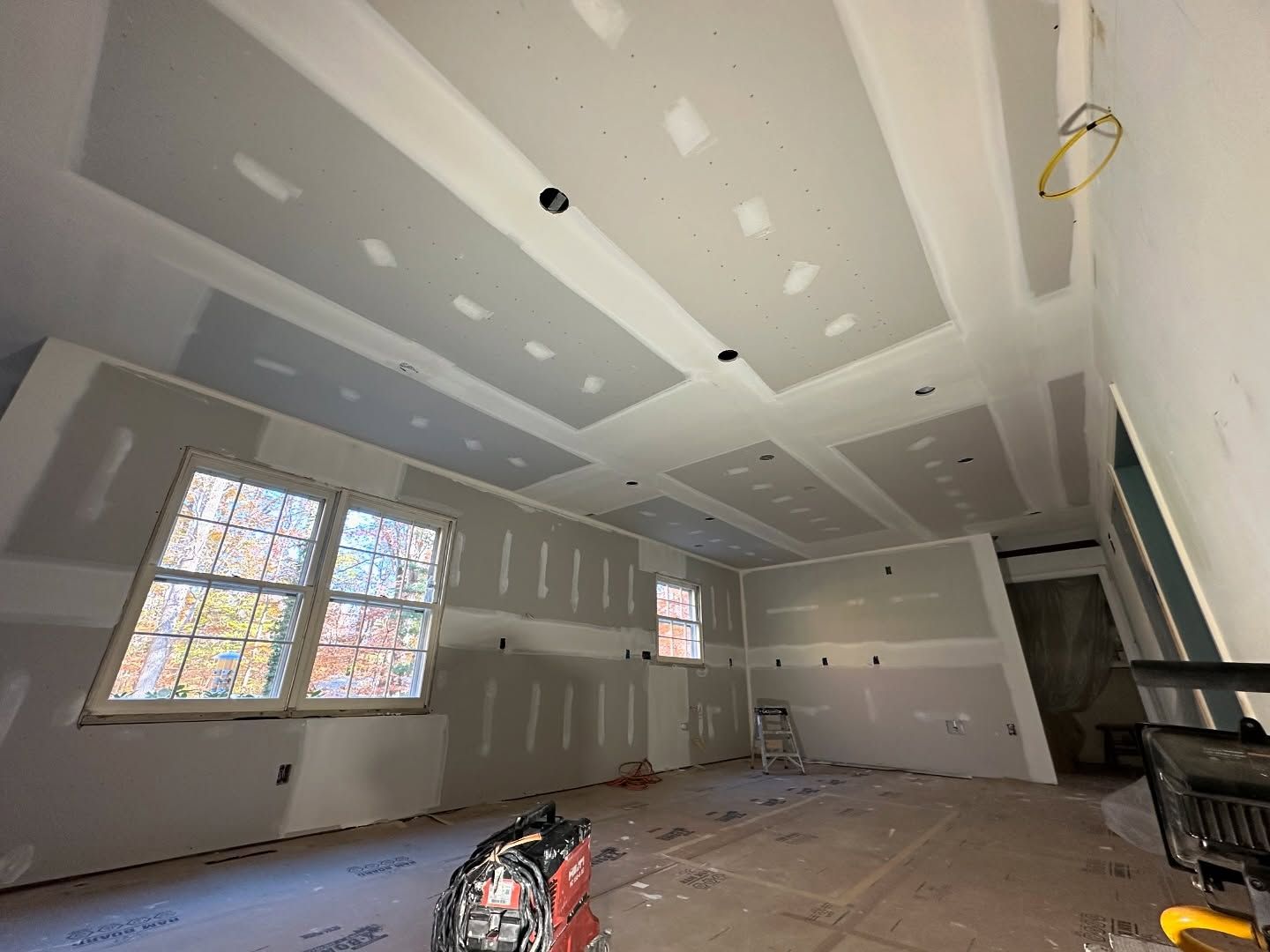 A room with a ceiling that is being built and a lot of windows.