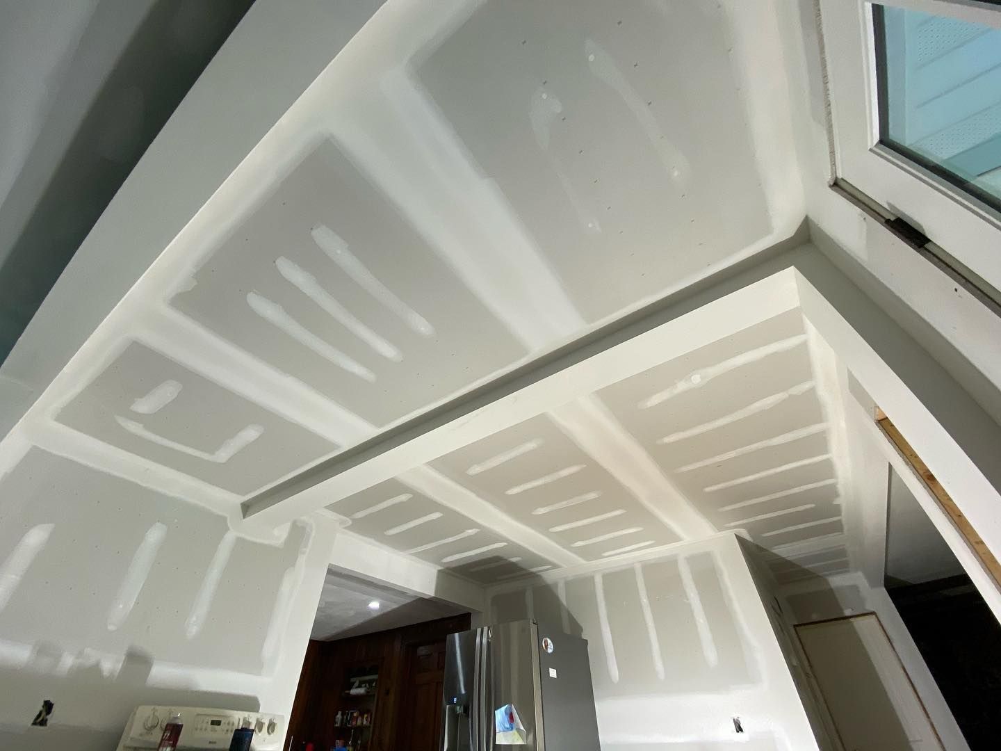 Looking up at the ceiling of a room with a window.