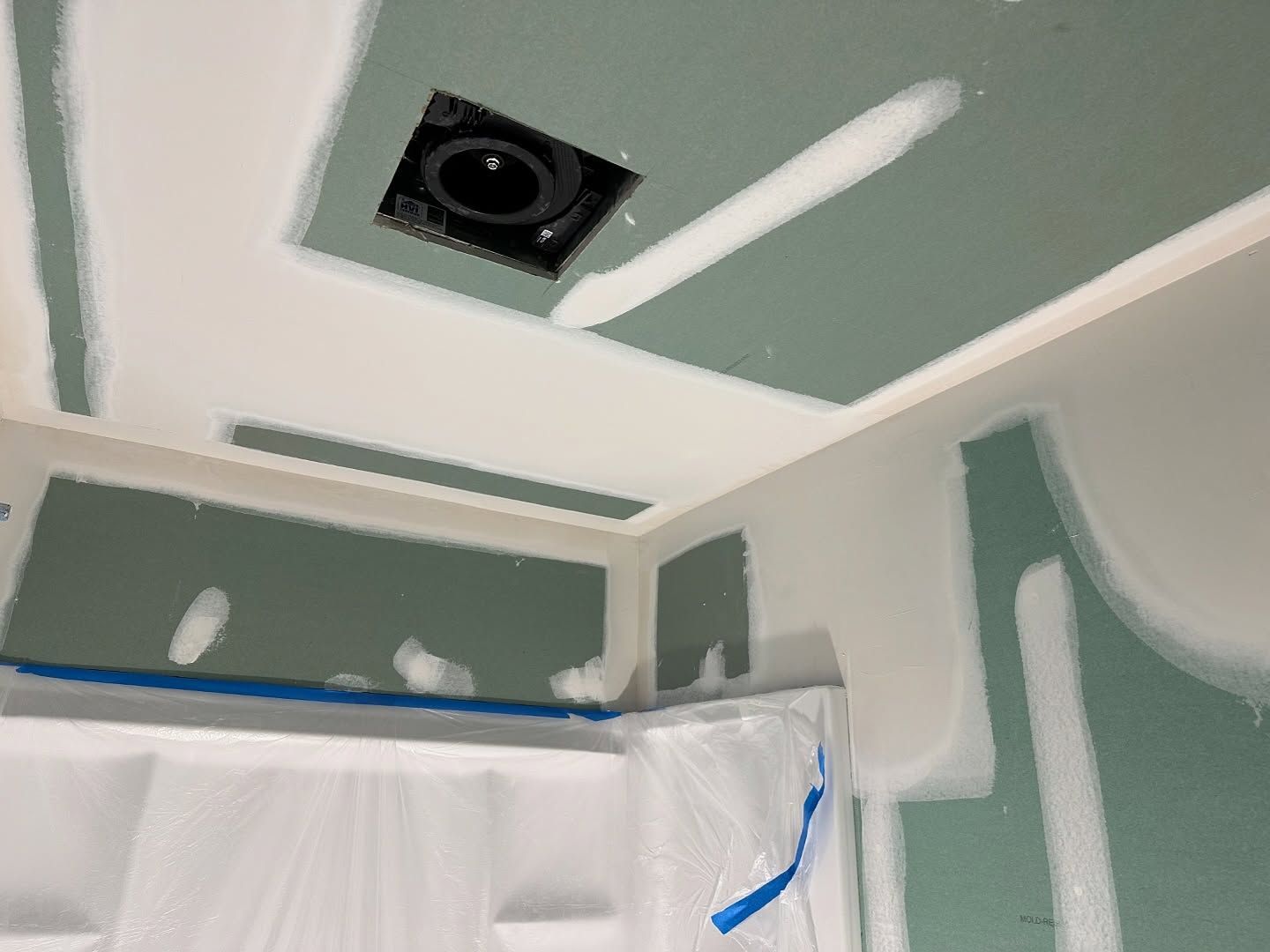 A ceiling with a hole in it and a fan on it