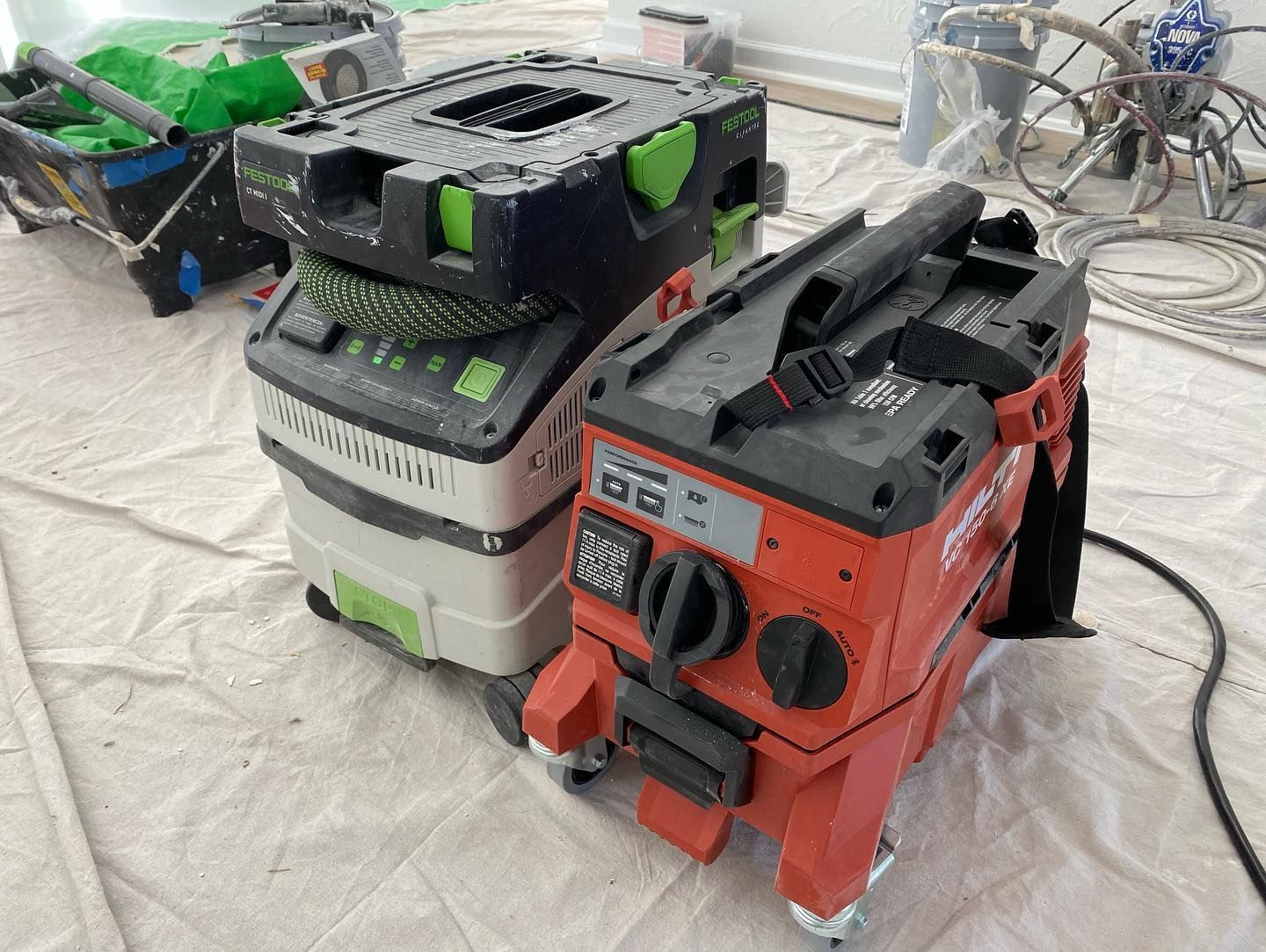 Two vacuum cleaners are stacked on top of each other on a table.