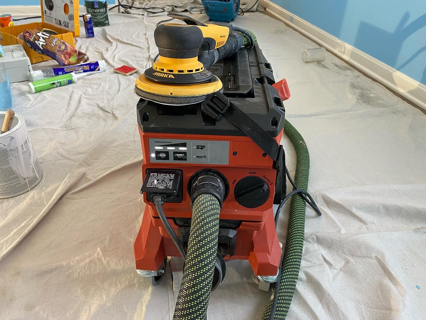 A vacuum cleaner is sitting on a table with a hose attached to it.