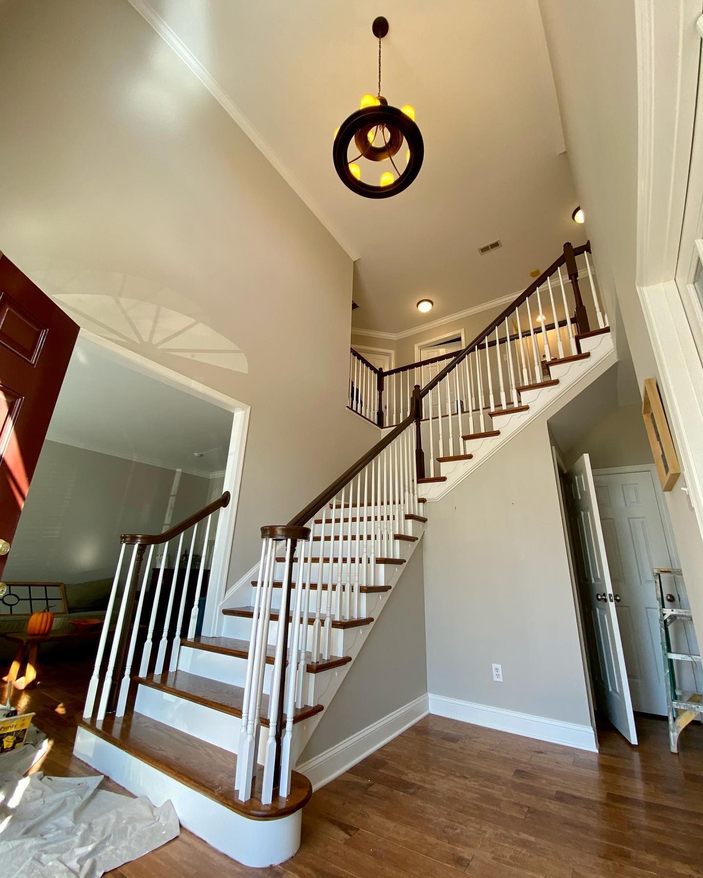 A staircase in a house with a chandelier hanging from the ceiling.