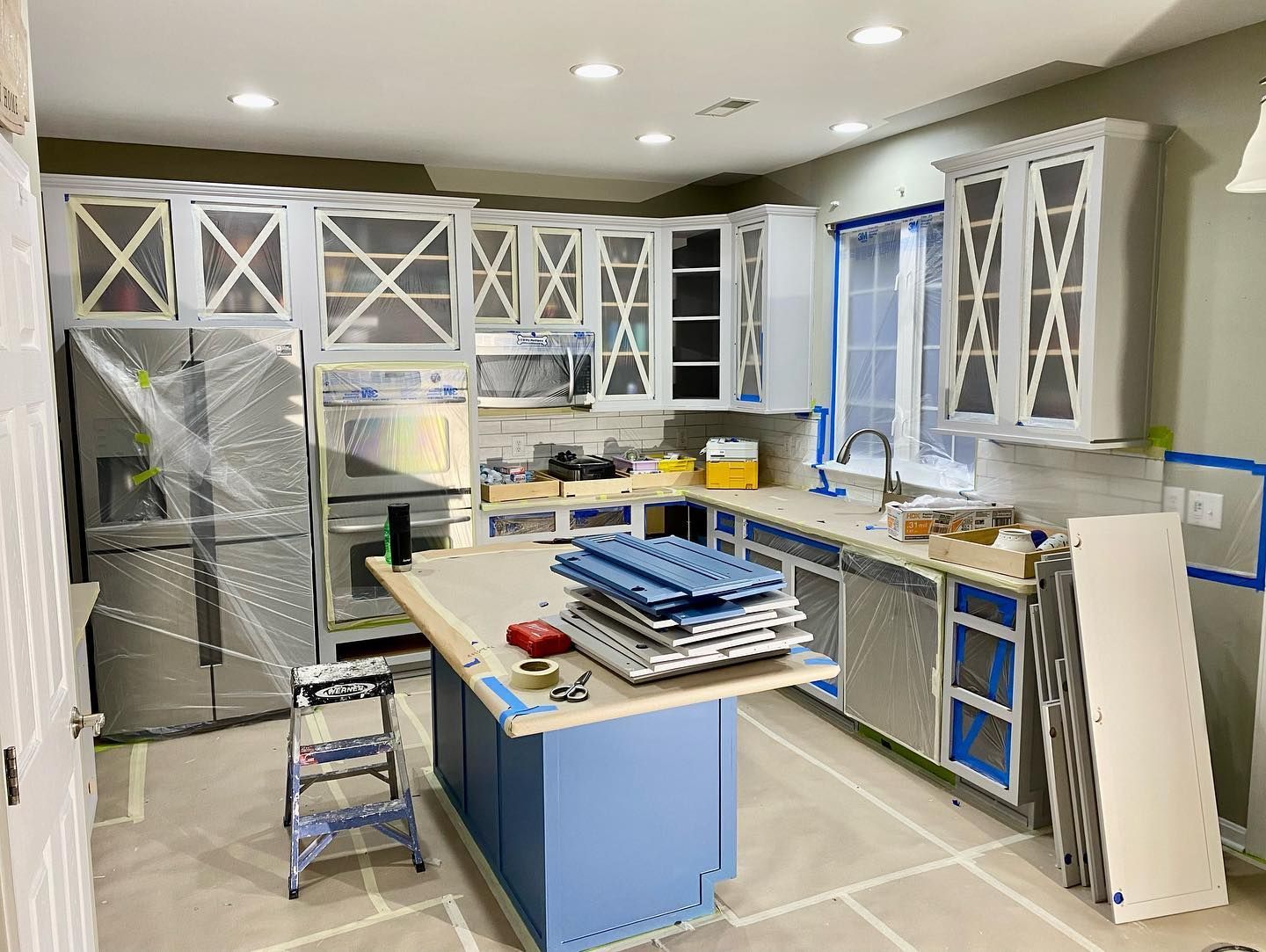 A kitchen is being remodeled with blue cabinets and white cabinets.