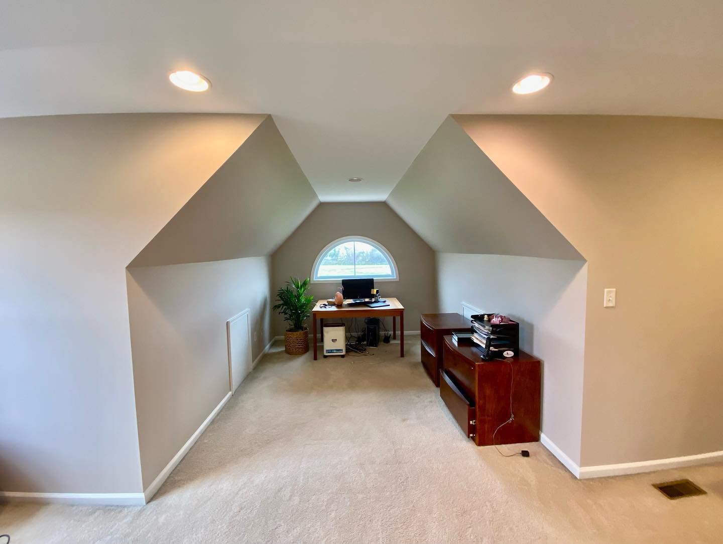 A room with a desk and a window in it