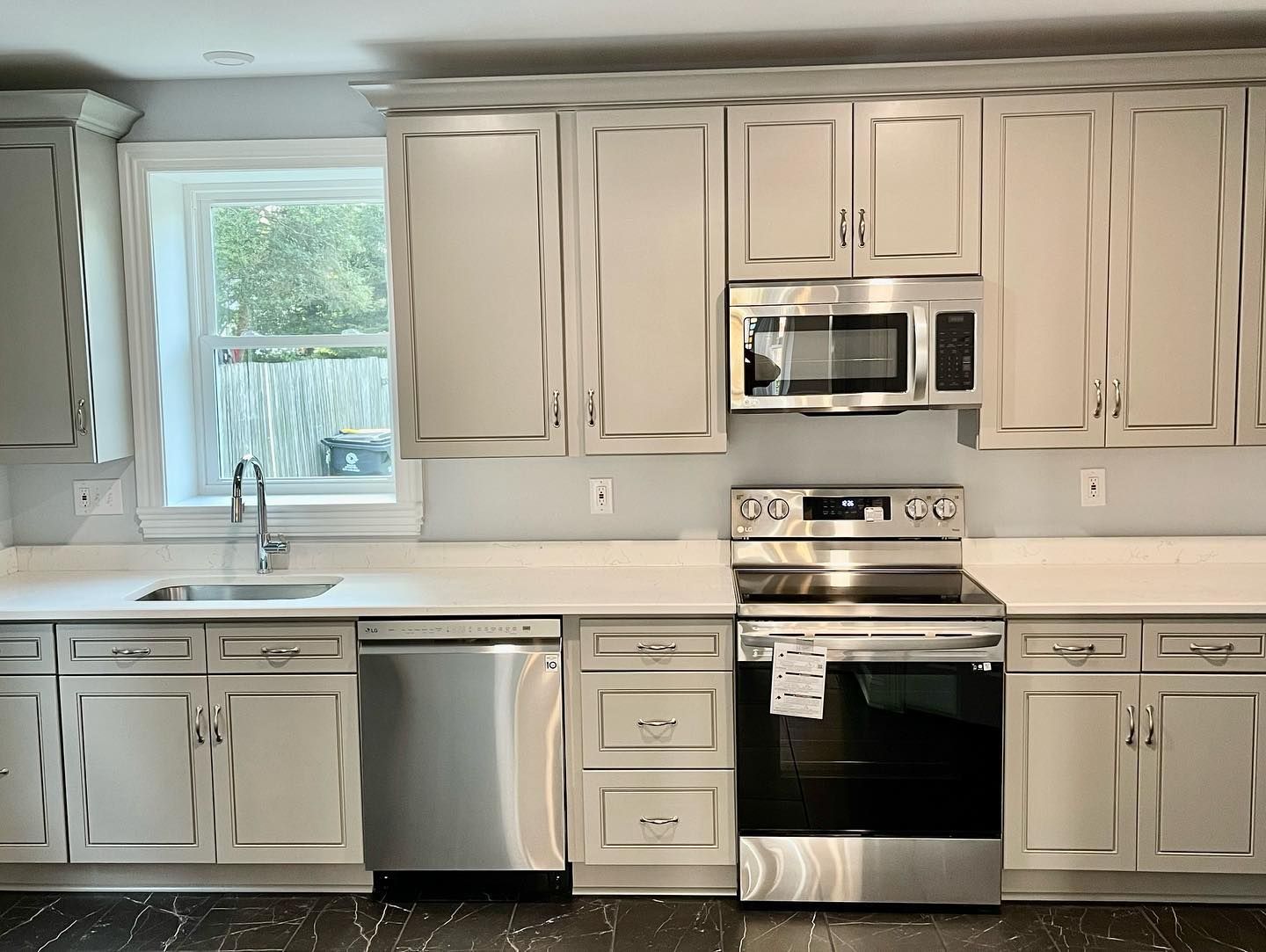 A kitchen with white cabinets and stainless steel appliances