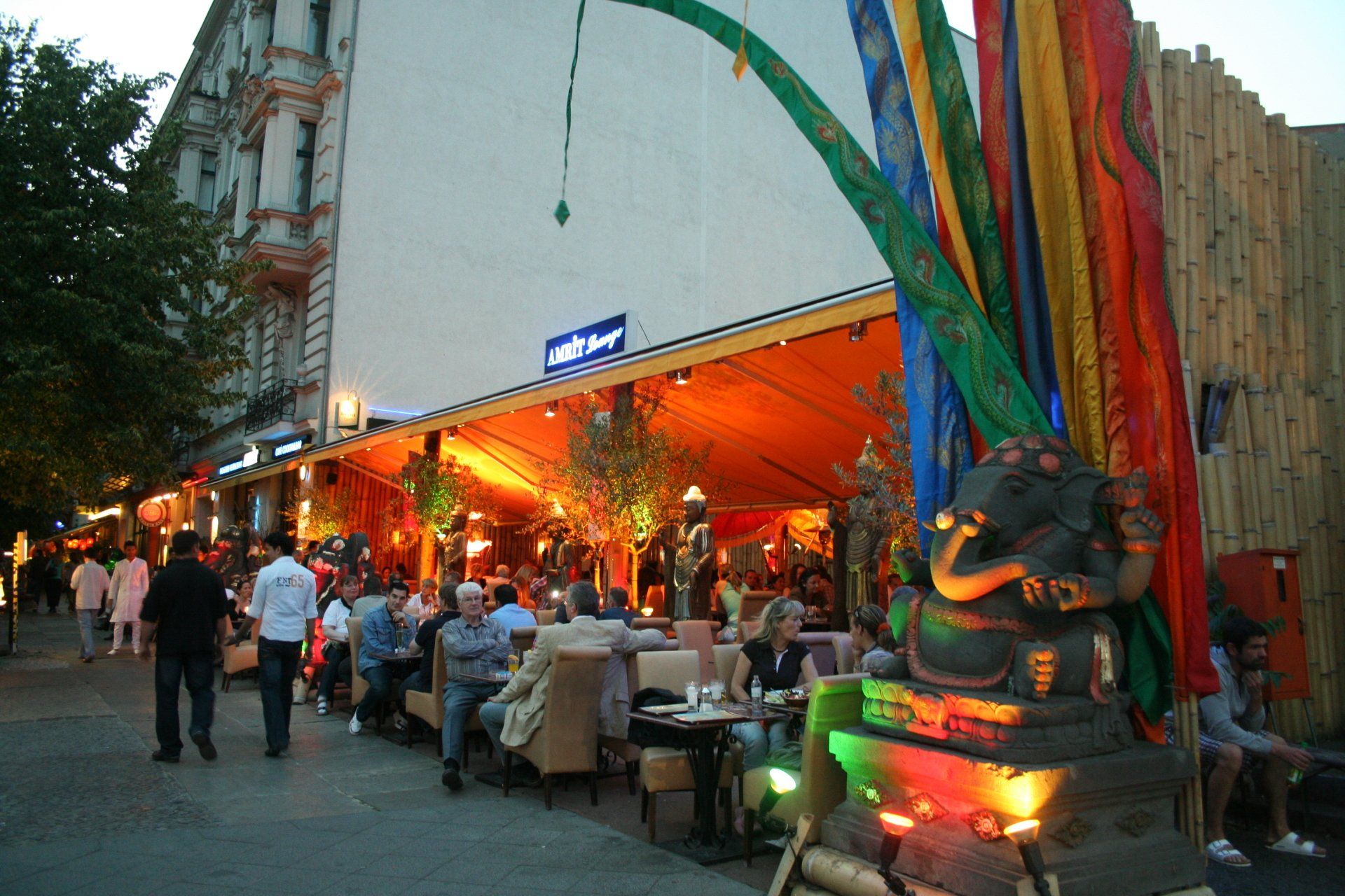 Eine Gruppe von Menschen sitzt an Tischen vor einem Restaurant