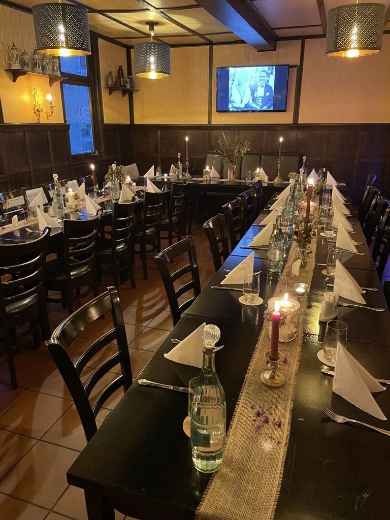 Ein langer Tisch in einem Restaurant mit Kerzen darauf