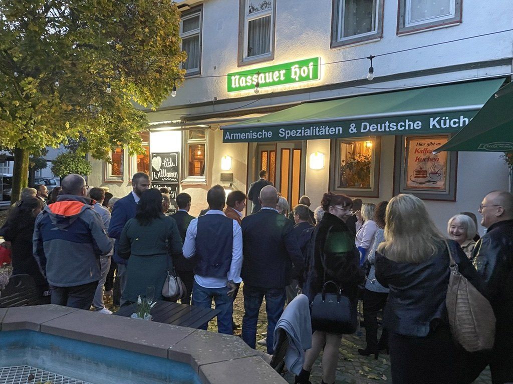 Eine große Gruppe von Menschen steht vor einem Restaurant