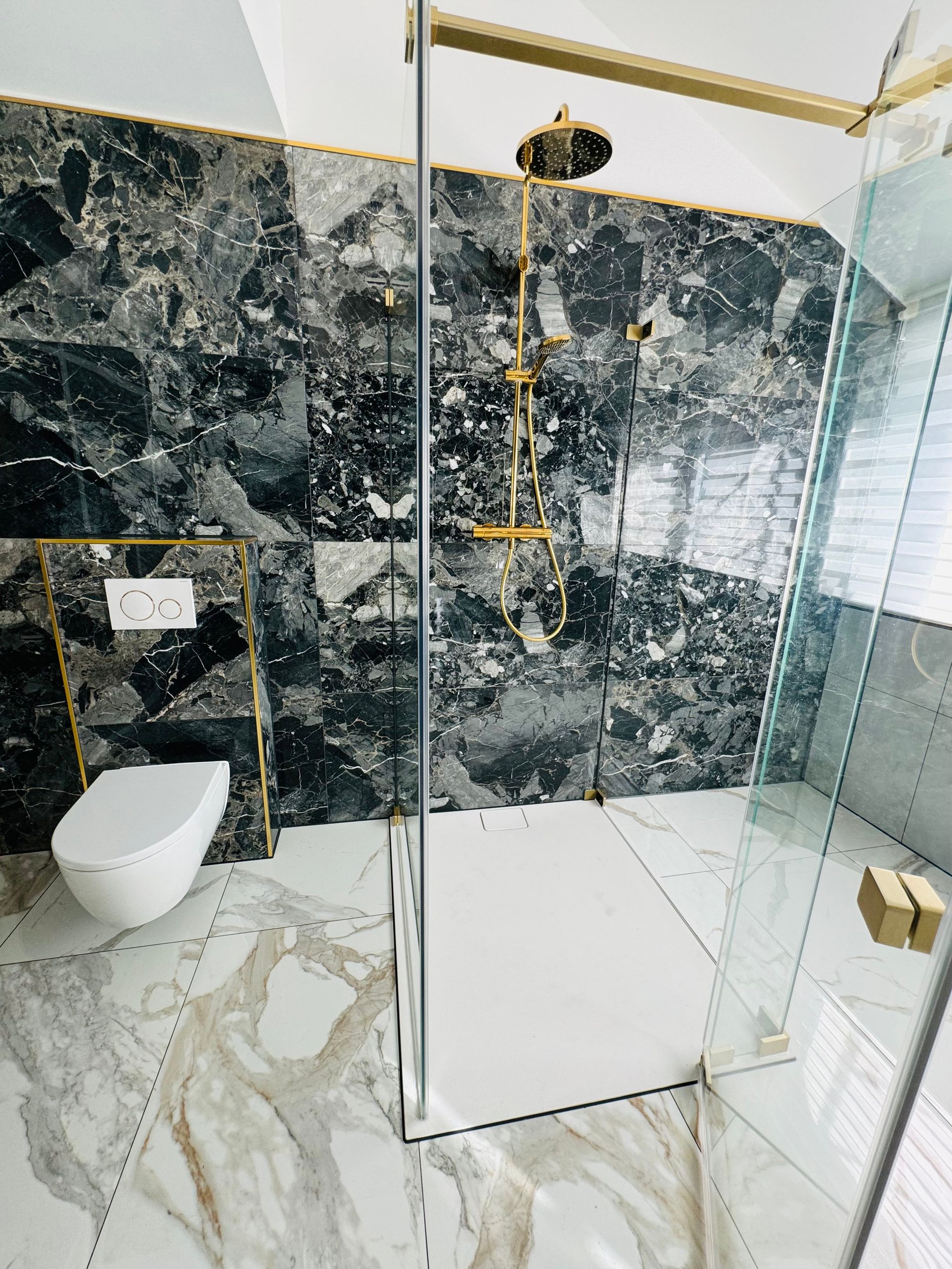 Ein Badezimmer mit ebenerdiger Dusche und Toilette.