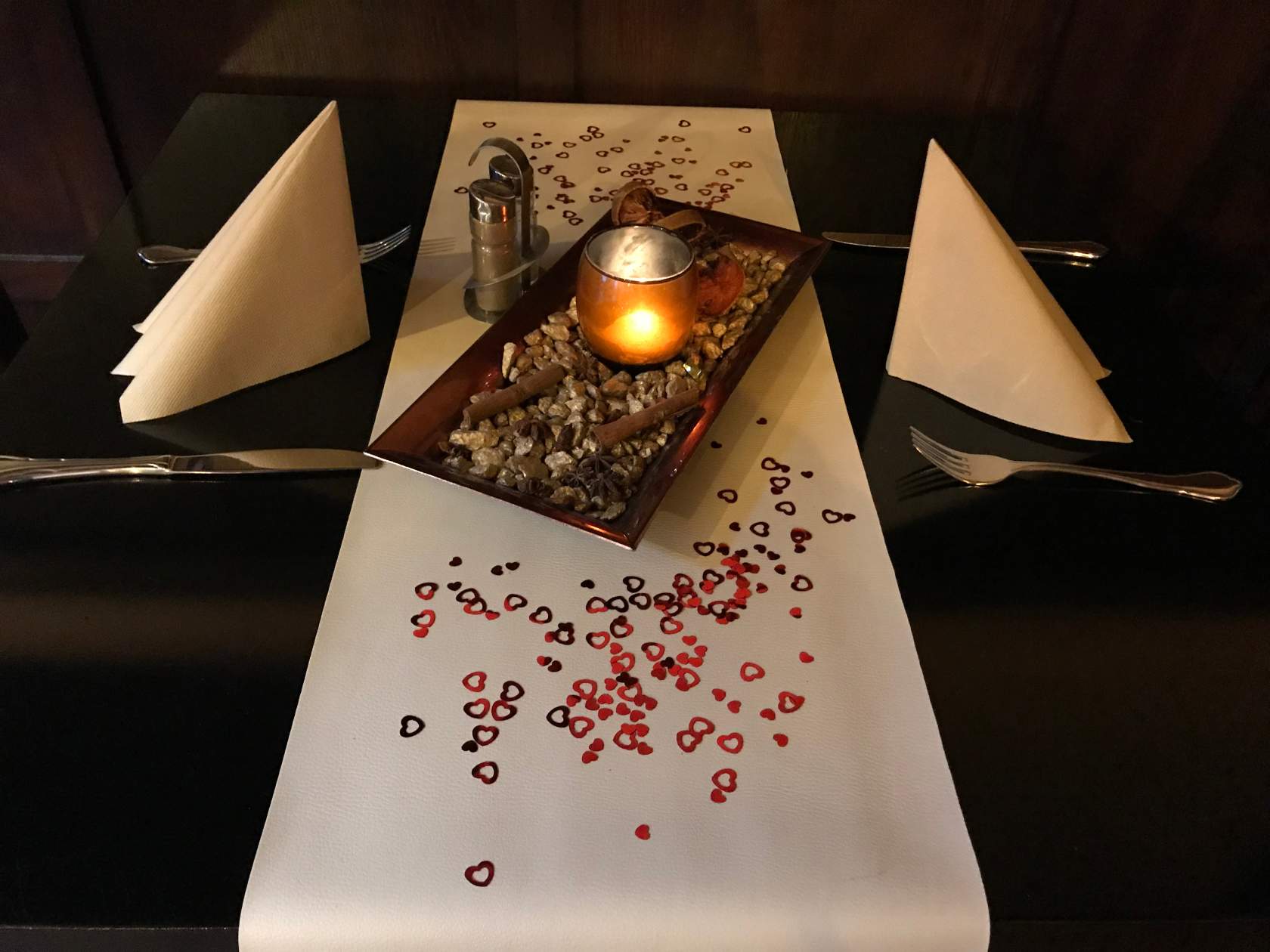 Ein Tisch mit einem Tablett mit Essen und einer Kerze darauf