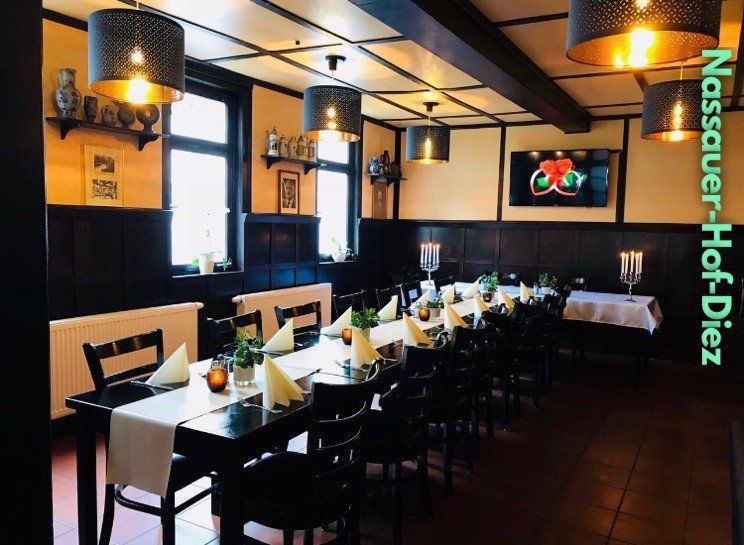 Ein Restaurant mit Tischen und Stühlen und einem Schild mit der Aufschrift „Nassauer-Hof-Diez“