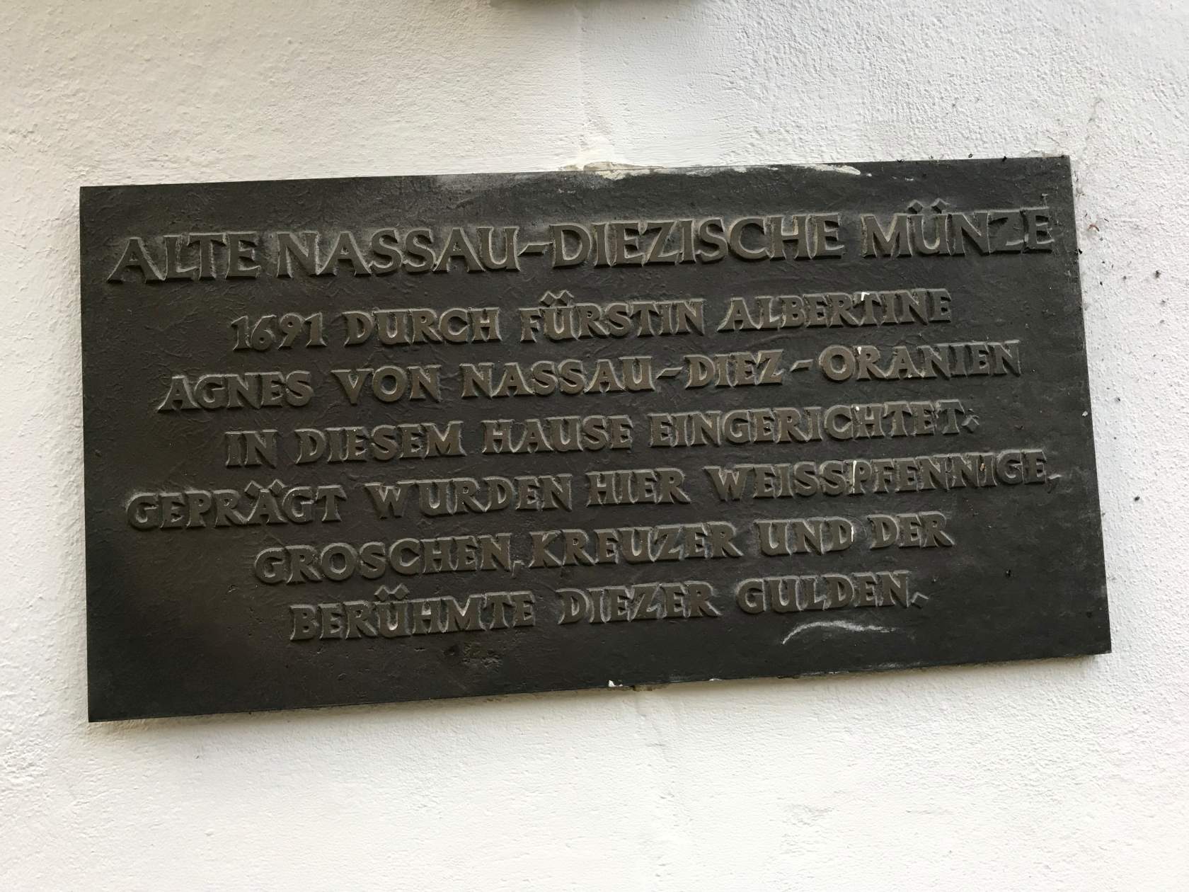 Eine Gedenktafel an einer Wand mit der Aufschrift 