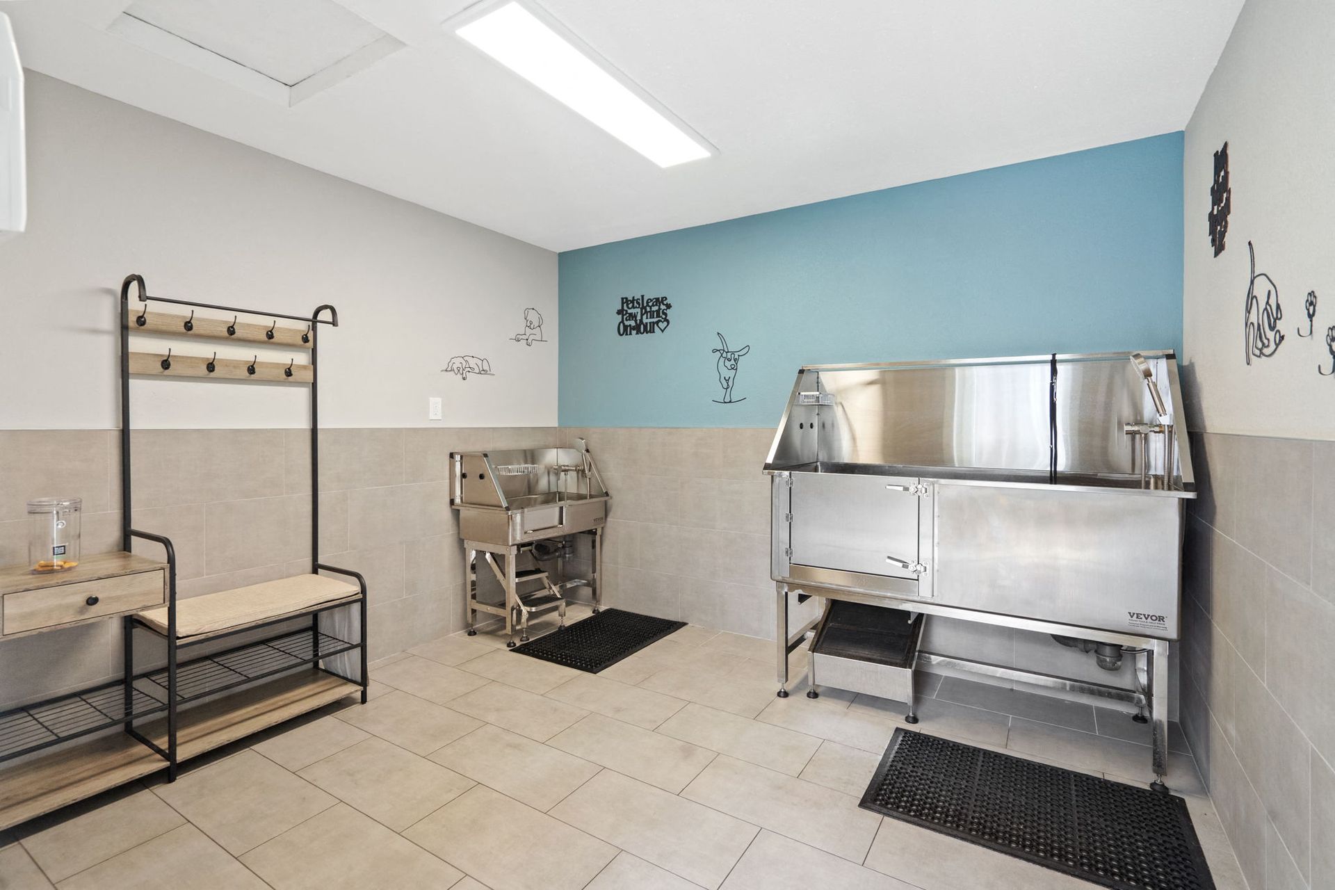 Community pet washing station with stainless steel tub, bench, and hooks.