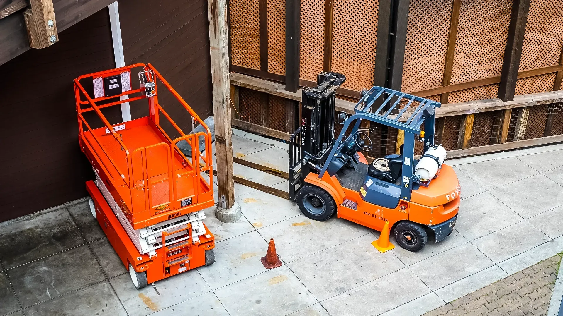 A forklift and scissor lift parked in a commercial jobsite area.