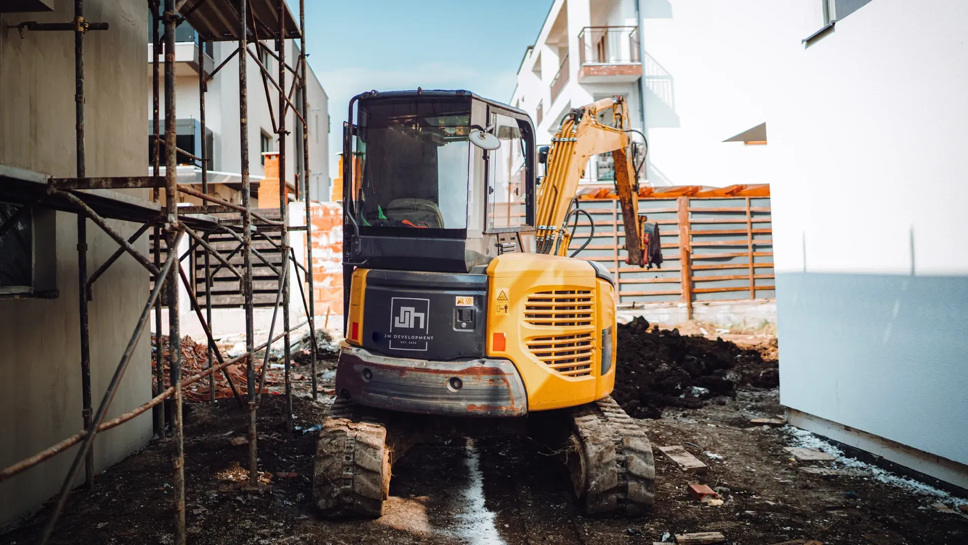 JM Development mini excavator parked on job site in Santa Fe Springs, CA