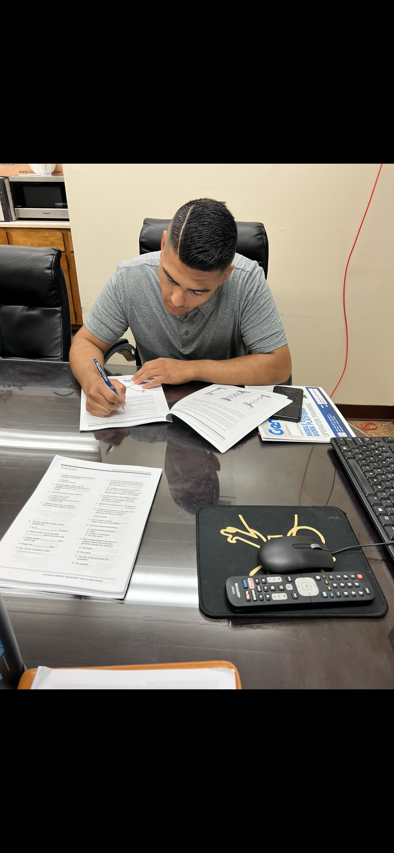 A man is sitting at a desk writing on a piece of paper.