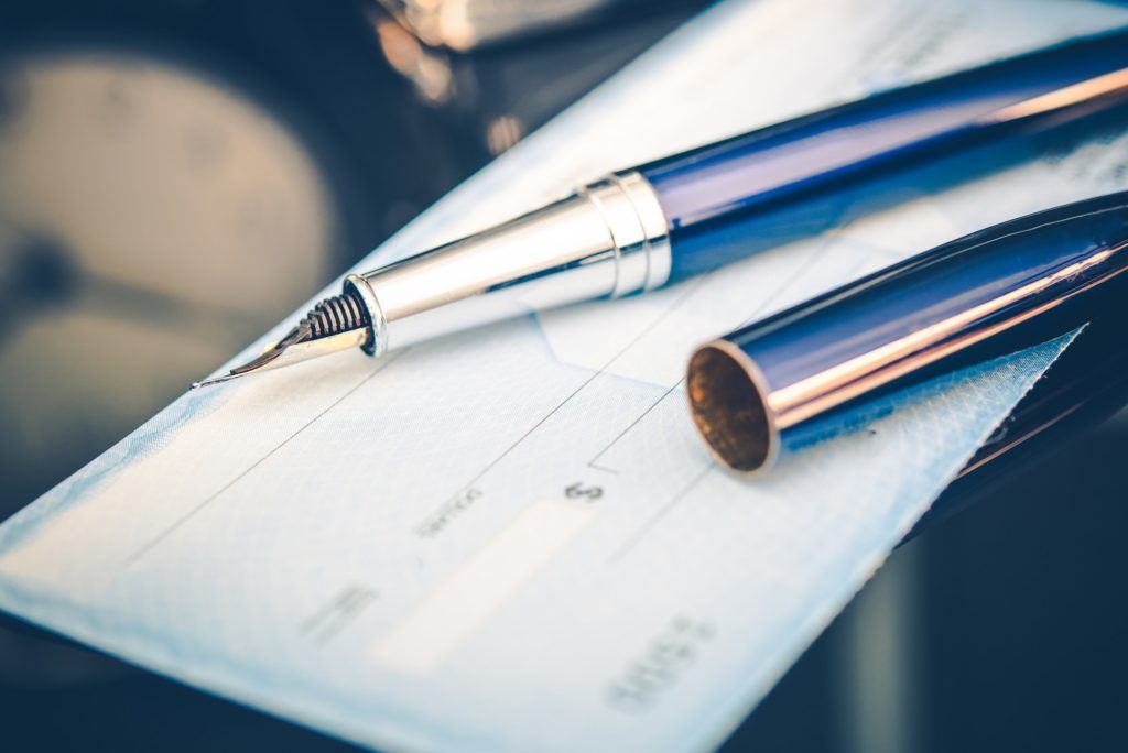 A pen is sitting on top of a check.