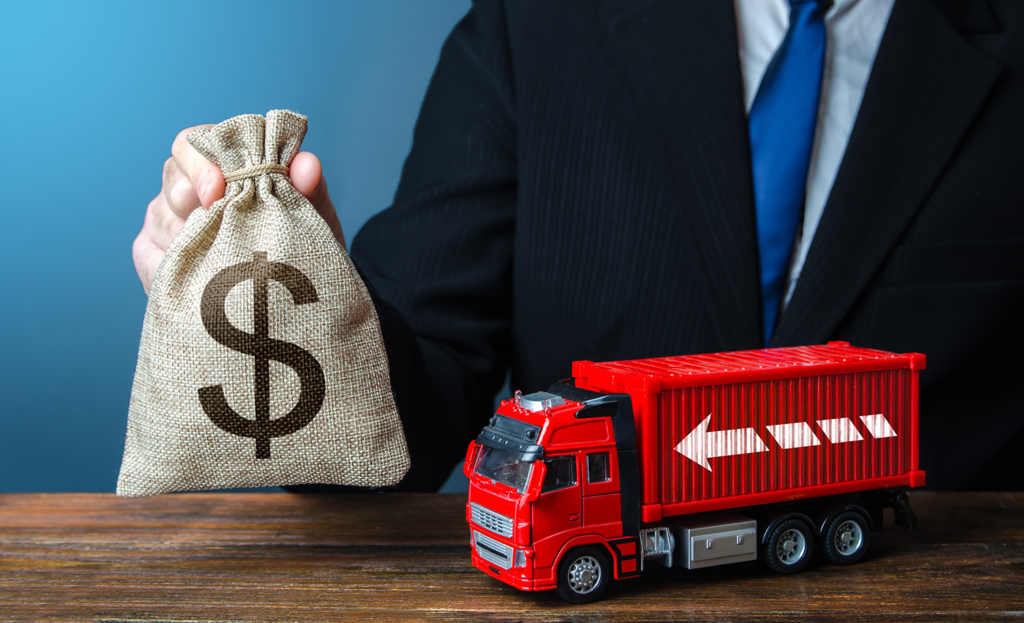 A man is holding a bag of money next to a toy truck.