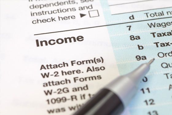A pen rests on top of a form that says income