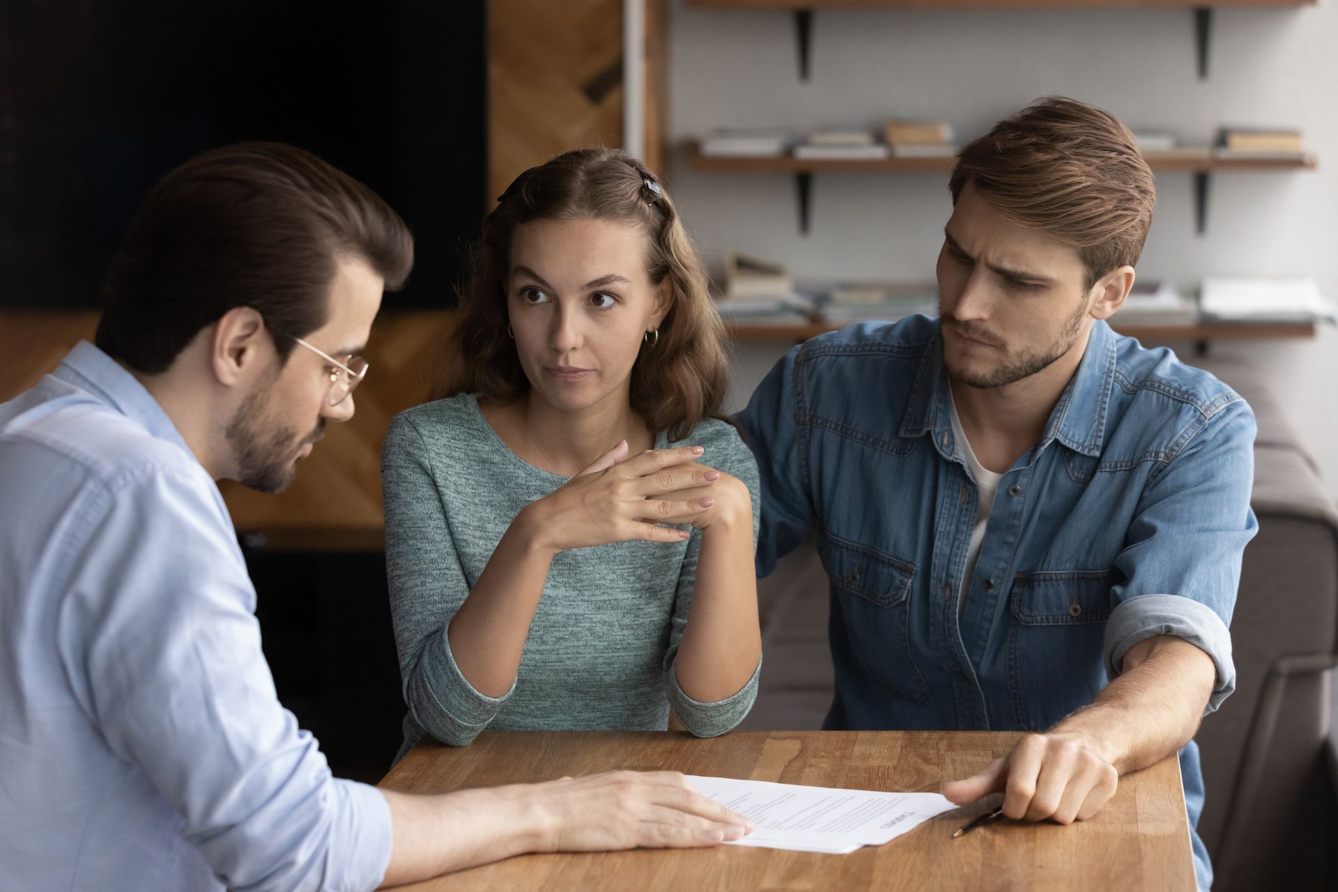 A man and a woman are sitting at a table looking at a piece of paper.