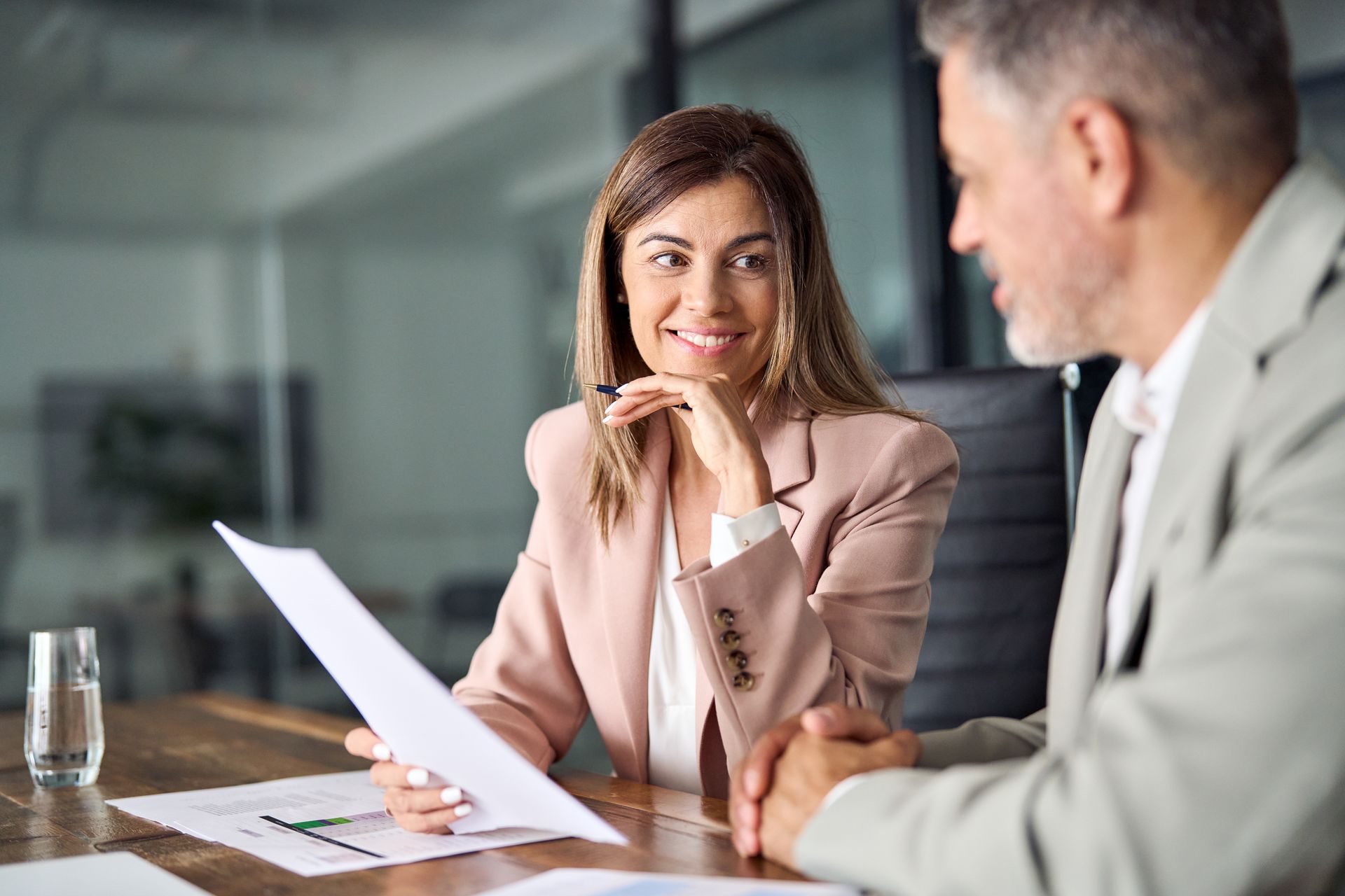 A man and a woman are sitting at a table looking at a piece of paper.