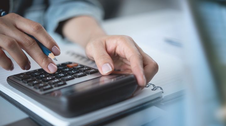 A person is using a calculator with a pencil.