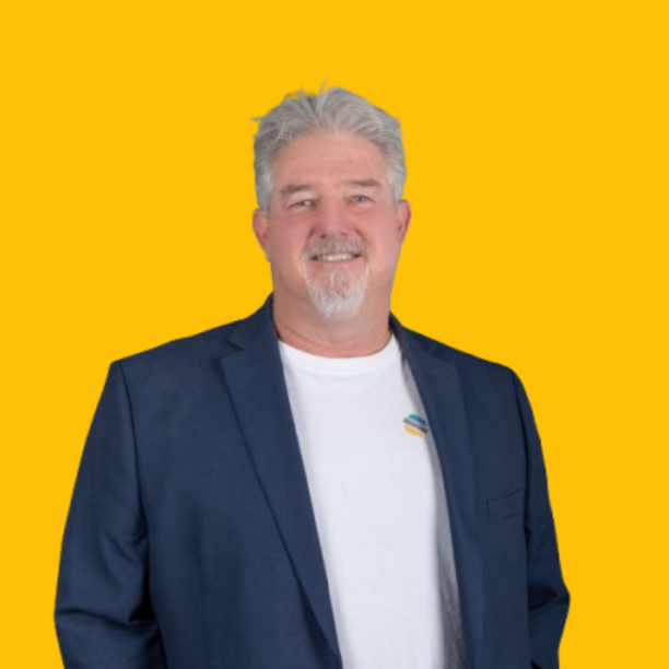 Buzz Howard in a suit and tie is smiling in front of a yellow background | Mortgage Lender in Roseville, CA
