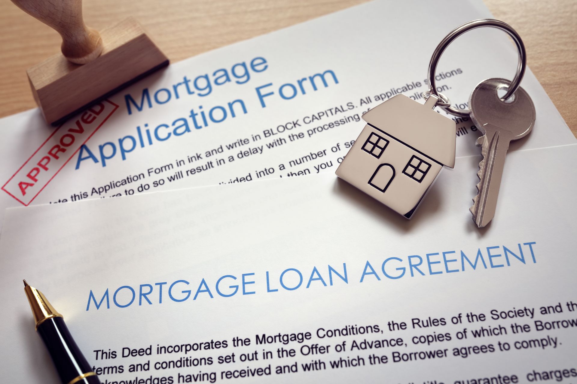A mortgage loan agreement is sitting on top of a mortgage application form.