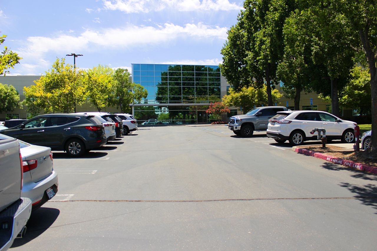 A lot of cars are parked in a parking lot in front of the building of a mortgage company in Roseville, CA. 