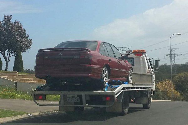 around the clock towing truck towing red car