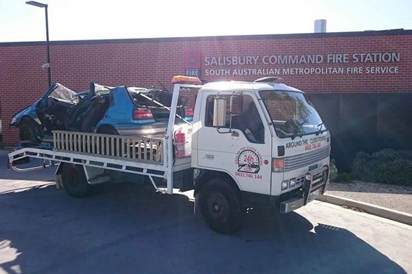 around the clock towing truck towing crumpled car