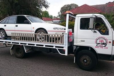 around the clock towing truck towing white car